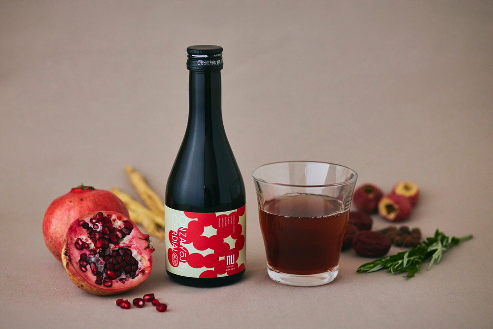 ザクロとグラスを添えたONZA 朱巡の飲用イメージ